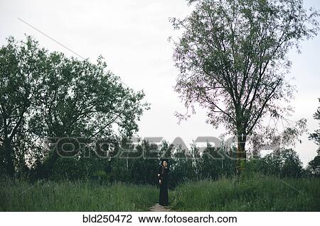 Middle Eastern woman wearing black dress on path in woods View Large Photo Image Stock Image - Middle Eastern woman wearing black dress on path in woods. Fotosearch