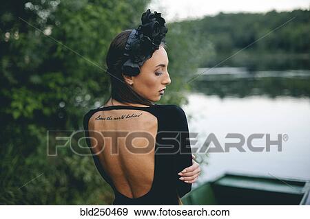 Stock Photo - Middle Eastern woman wearing black dress in boat on lake. Fotosearch