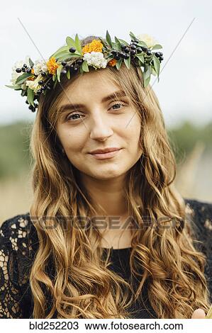 Stock Image - Middle Eastern woman wearing flower crown outdoors. Fotosearch