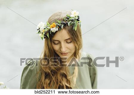 Stock Image - Middle Eastern woman wearing flower crown looking down. Fotosearch