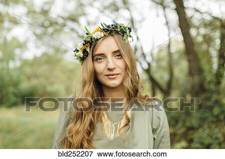 Stock Photo - Middle Eastern woman wearing flower crown in woods. Fotosearch