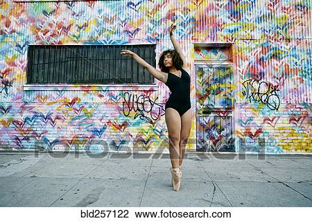 Stock Image - Mixed race ballet dancer on sidewalk. Fotosearch