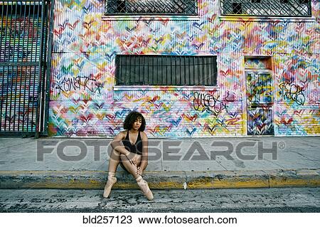 Mixed race ballet dancer sitting on curb rubbing leg View Large Photo Image Stock Image - Mixed race ballet dancer sitting on curb rubbing leg. Fotosearch