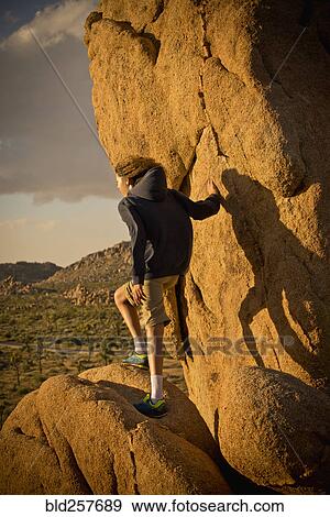 Mixed race boy standing on rock in desert View Large Photo Image Stock Photo - Mixed race boy standing on rock in desert. Fotosearch