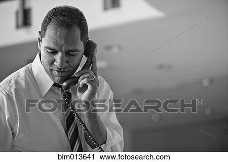 Stock Image - Mixed race businessman talking on telephone. Fotosearch