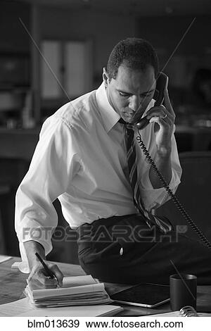Stock Photo - Mixed race businessman talking on telephone. Fotosearch