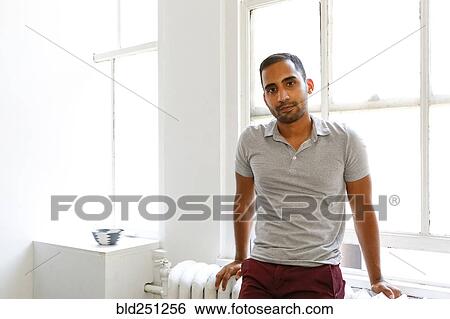 Stock Photograph - Mixed race man leaning on radiator. Fotosearch