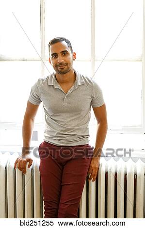 Stock Photography - Mixed race man leaning on radiator. Fotosearch