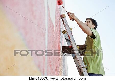 Mixed race man painting wall View Large Photo Image Stock Photograph - Mixed race man painting wall. Fotosearch