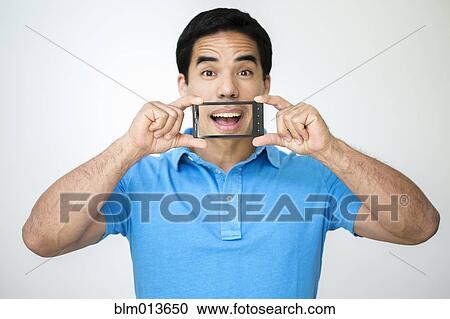 Stock Image - Mixed race man taking digital picture. Fotosearch