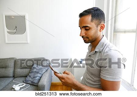 Mixed-race man texting on cell phone View Large Photo Image Stock Image - Mixed-race man texting on cell phone. Fotosearch