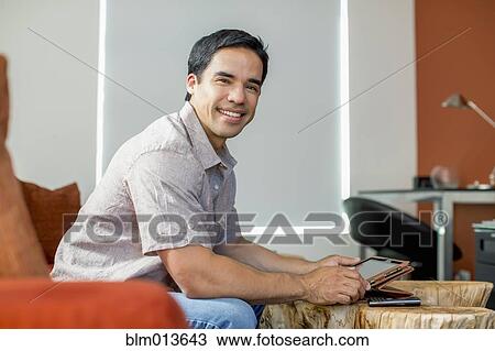 Mixed race man using digital tablet View Large Photo Image Stock Image - Mixed race man using digital tablet. Fotosearch