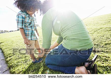 Mixed race mother tying shoe of son View Large Photo Image Stock Image - Mixed race mother tying shoe of son. Fotosearch