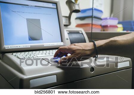 Stock Image - Mixed race nurses using fingerprint scanner. Fotosearch