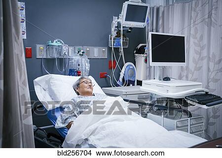 Picture - Mixed race patient in hospital bed. Fotosearch