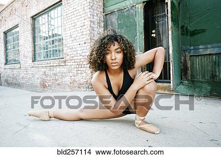 Picture - Mixed race woman dancing ballet in city. Fotosearch