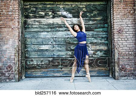 Stock Photograph - Mixed race woman dancing ballet in city. Fotosearch