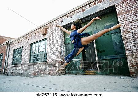 Stock Photography - Mixed race woman dancing ballet in city. Fotosearch