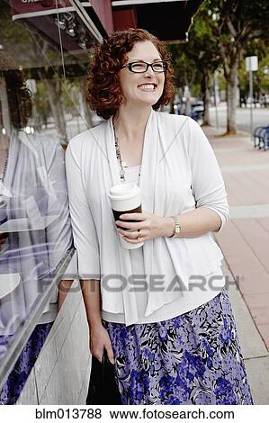 Mixed race woman drinking coffee on sidewalk View Large Photo Image Stock Photo - Mixed race woman drinking coffee on sidewalk. Fotosearch