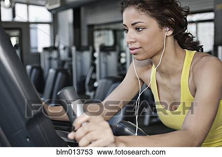 Mixed race woman exercising in health club View Large Photo Image Stock Image - Mixed race woman exercising in health club. Fotosearch