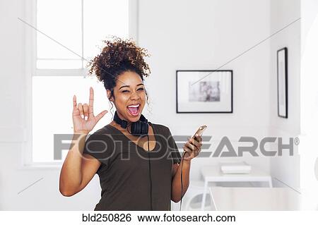 Mixed race woman gesturing and holding cell phone View Large Photo Image Stock Photograph - Mixed race woman gesturing and holding cell phone. Fotosearch