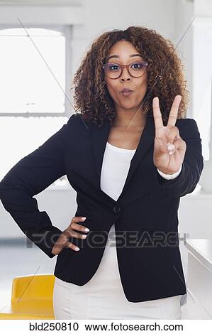 Mixed race woman gesturing peace in gallery View Large Photo Image Stock Image - Mixed race woman gesturing peace in gallery. Fotosearch