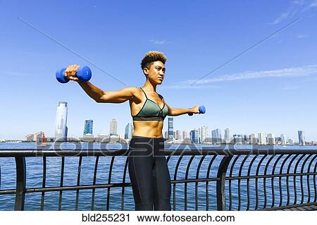 Mixed race woman lifting dumbbells at waterfront View Large Photo Image Stock Image - Mixed race woman lifting dumbbells at waterfront. Fotosearch
