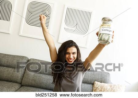 Mixed race woman on sofa celebrating with college money View Large Photo Image Stock Photo - Mixed race woman on sofa celebrating with college money. Fotosearch