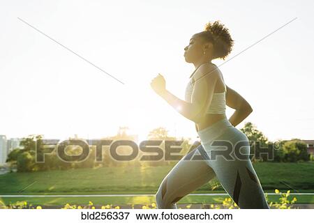 Stock Photo - Mixed Race woman running in park. Fotosearch