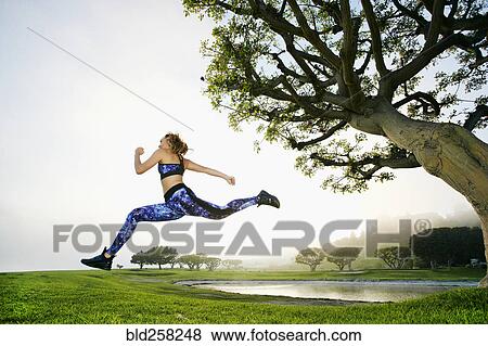 Mixed race woman running near lake View Large Photo Image Stock Photo - Mixed race woman running near lake. Fotosearch