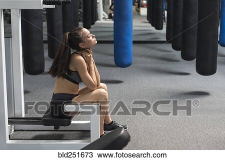 Mixed race woman sitting in gymnasium rubbing neck View Large Photo Image Stock Image - Mixed race woman sitting in gymnasium rubbing neck. Fotosearch