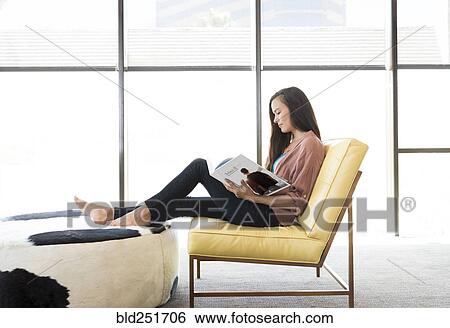 Mixed race woman sitting on chair reading book View Large Photo Image Stock Photograph - Mixed race woman sitting on chair reading book. Fotosearch