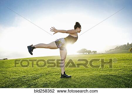 Mixed race woman standing on one leg in field View Large Photo Image Stock Image - Mixed race woman standing on one leg in field. Fotosearch