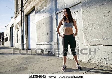 Stock Image - Mixed race woman standing on sidewalk. Fotosearch