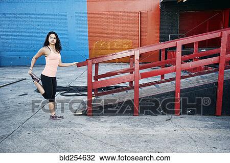 Mixed race woman stretching leg at loading dock View Large Photo Image Stock Image - Mixed race woman stretching leg at loading dock. Fotosearch