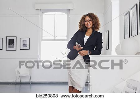 Mixed race woman texting on cell phone in gallery View Large Photo Image Stock Photo - Mixed race woman texting on cell phone in gallery. Fotosearch