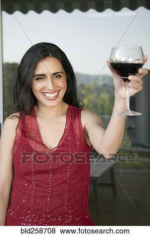 Stock Photo - Mixed race woman toasting with wine. Fotosearch