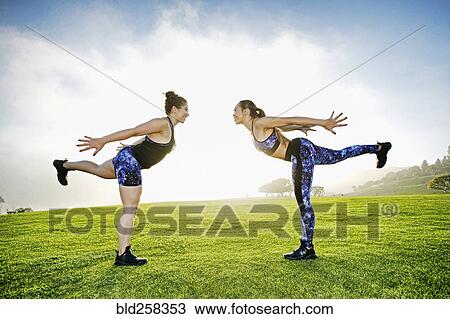 Mixed race women standing on one leg in field View Large Photo Image Stock Image - Mixed race women standing on one leg in field. Fotosearch