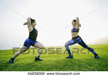 Mixed race women stretching arms in field View Large Photo Image Stock Photo - Mixed race women stretching arms in field. Fotosearch