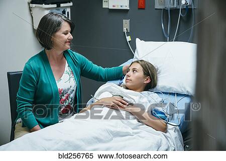 Stock Photography - Mother comforting daughter in hospital bed. Fotosearch