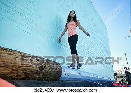 Stock Photo - Next race woman walking near blue wall. Fotosearch