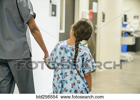 Nurse holding hands with girl in hospital View Large Photo Image Picture - Nurse holding hands with girl in hospital. Fotosearch