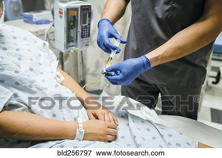 Nurse injecting medicine into tube of patient View Large Photo Image Stock Photo - Nurse injecting medicine into tube of patient. Fotosearch