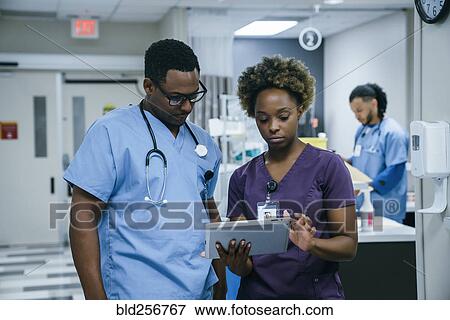Stock Photo - Nurse is using digital tablet in hospital. Fotosearch