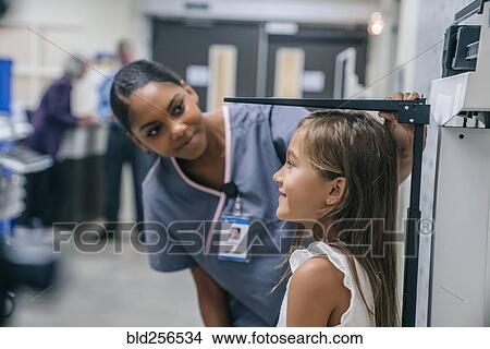 Picture - Nurse measuring height of girl. Fotosearch