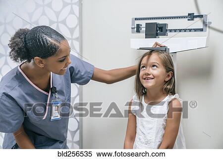 Stock Photography - Nurse measuring height of girl. Fotosearch