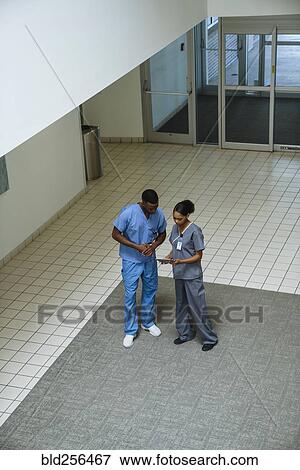 Stock Photo - Nurses discussing digital tablet. Fotosearch