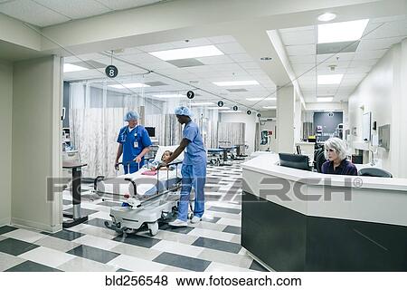 Stock Photo - Nurses pushing gurney in hospital. Fotosearch