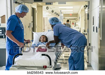Nurses talking to girl in hospital gurney View Large Photo Image Stock Image - Nurses talking to girl in hospital gurney. Fotosearch