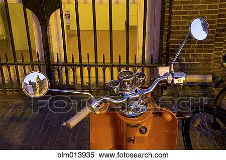 Stock Photography - Old-fashioned scooter parked on urban sidewalk. Fotosearch